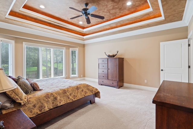 bedroom with a tray ceiling, recessed lighting, light colored carpet, and crown molding