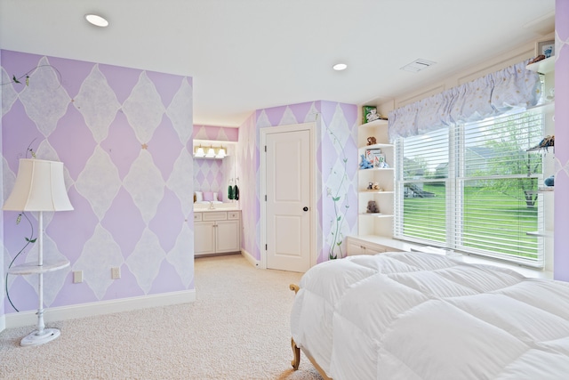 bedroom with wallpapered walls, visible vents, light carpet, baseboards, and ensuite bathroom