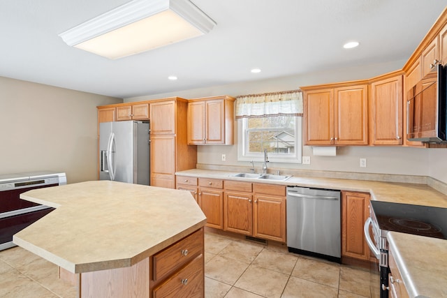 kitchen featuring stainless steel appliances, a center island, a sink, visible vents, and light countertops