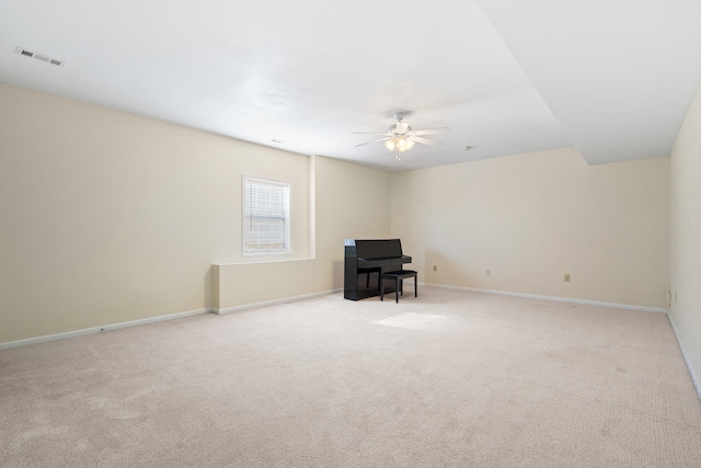 carpeted spare room featuring baseboards, a ceiling fan, and visible vents