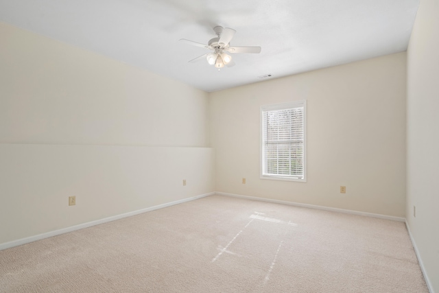 empty room with ceiling fan, baseboards, and light colored carpet