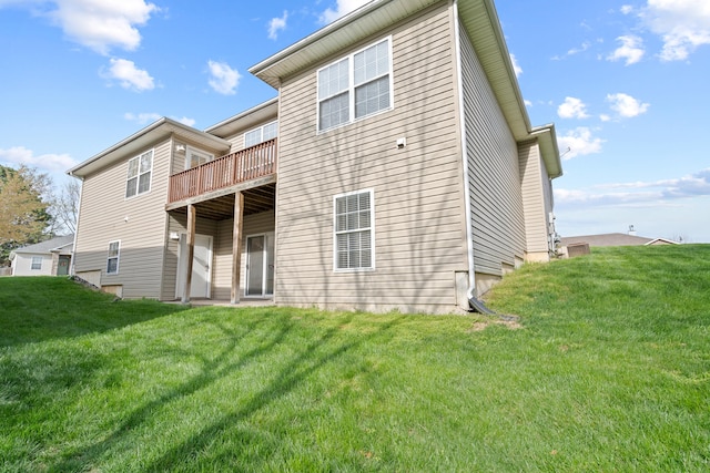 rear view of property featuring a yard and a deck