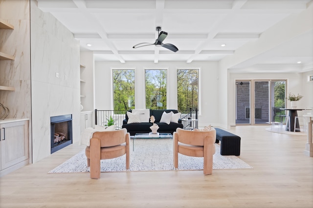 living area featuring wood finished floors, recessed lighting, a ceiling fan, coffered ceiling, and a premium fireplace