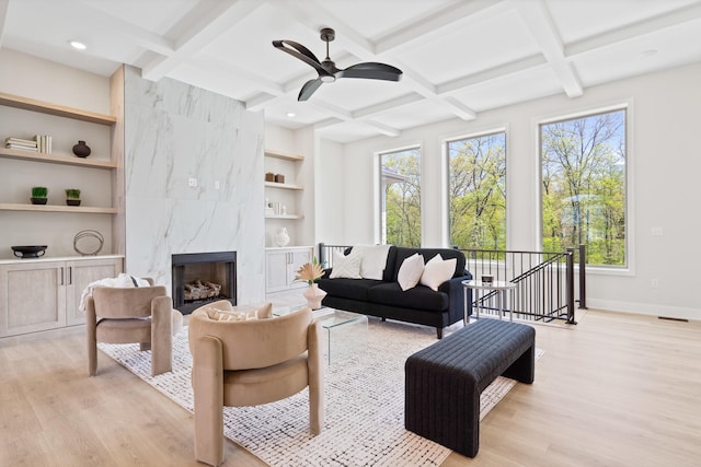 living room with light wood-type flooring, baseboards, and plenty of natural light