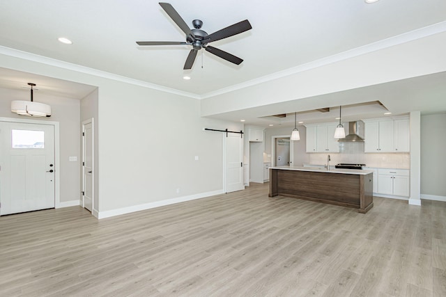 709 Sagemoor Dr, Columbia, MO 65201 - kitchen with a barn door, light countertops, wall chimney range hood, light wood-style floors, and baseboards