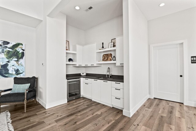 709 Sagemoor Dr, Columbia, MO 65201 - kitchen featuring wine cooler, open shelves, dark countertops, visible vents, and a sink