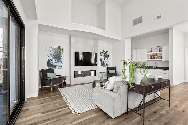 709 Sagemoor Dr, Columbia, MO 65201 - living area featuring visible vents, baseboards, light wood-style flooring, and a towering ceiling