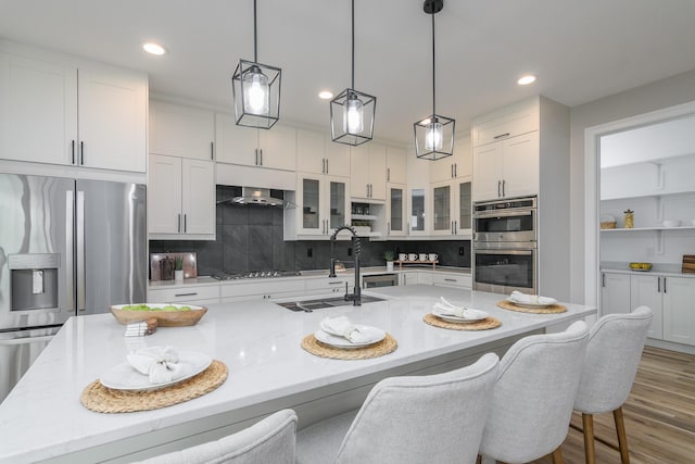 6301 Crooked Switch Ct, Columbia, MO 65201 - kitchen with stainless steel appliances, white cabinetry, a spacious island, glass insert cabinets, and recessed lighting