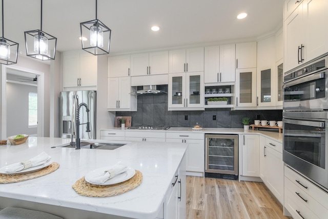 6301 Crooked Switch Ct, Columbia, MO 65201 - kitchen featuring beverage cooler, stainless steel appliances, white cabinetry, decorative backsplash, and light wood-type flooring