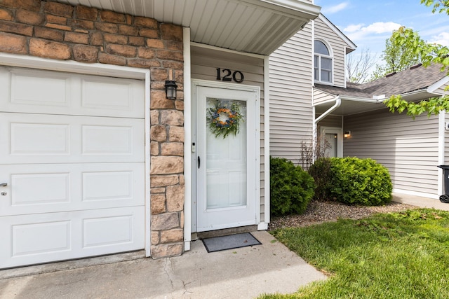 property entrance with a shingled roof and stone siding