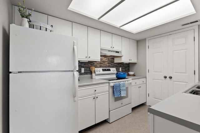 kitchen featuring white appliances, white cabinetry, light tile patterned floors, backsplash, and under cabinet range hood