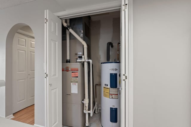 utility room with water heater and electric water heater