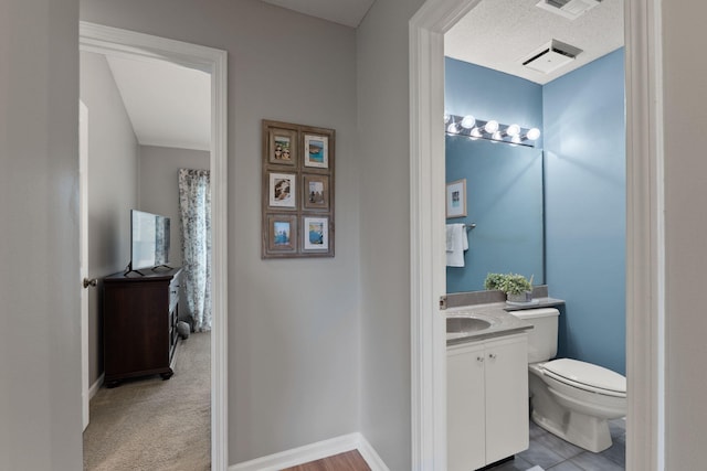 bathroom featuring toilet, baseboards, visible vents, and vanity
