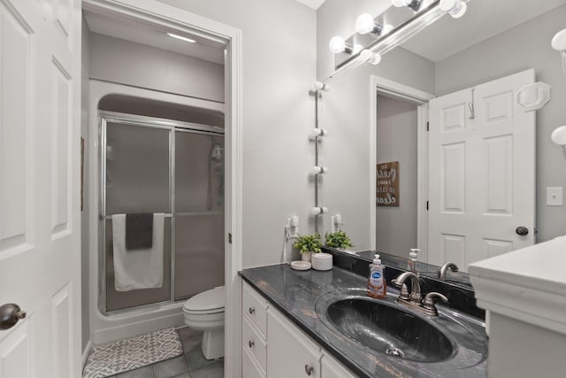 full bathroom with toilet, a shower stall, tile patterned flooring, and vanity