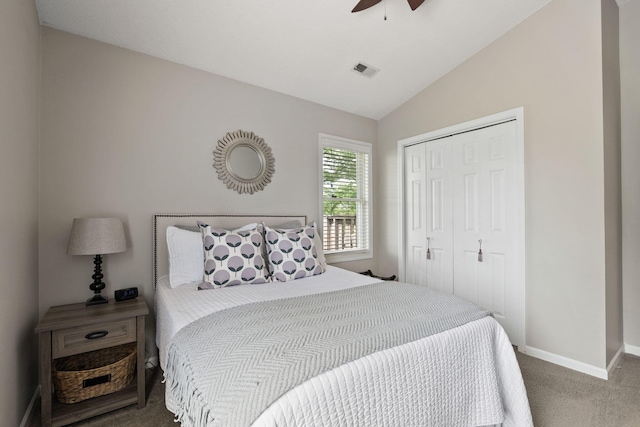 carpeted bedroom featuring a ceiling fan, baseboards, lofted ceiling, visible vents, and a closet