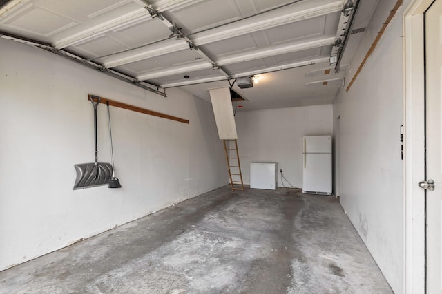 garage with freestanding refrigerator and a garage door opener