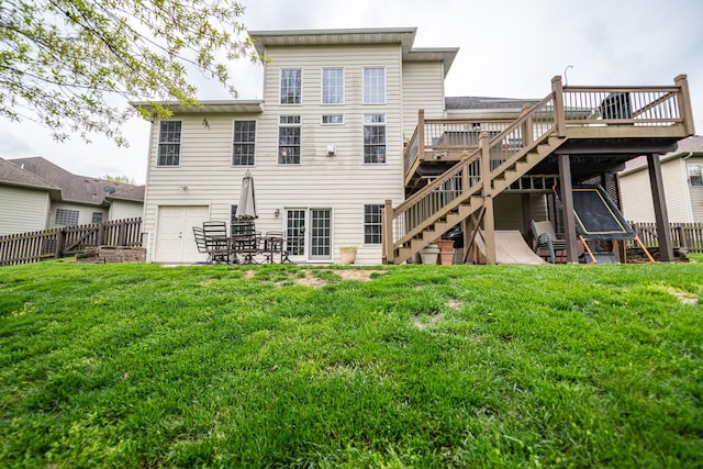 back of property featuring a deck, a fenced backyard, a lawn, and stairs