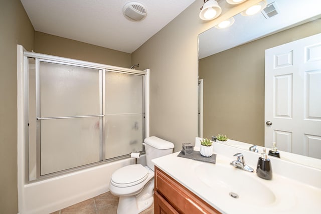 full bath with tile patterned flooring, toilet, vanity, visible vents, and bath / shower combo with glass door