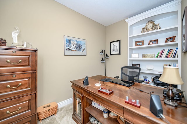 home office with baseboards and light colored carpet