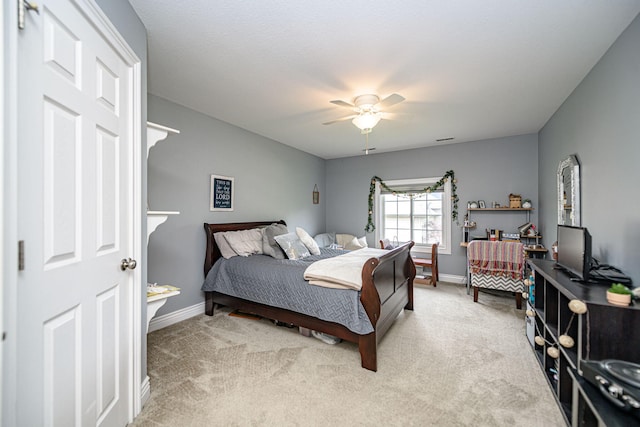 bedroom featuring ceiling fan, baseboards, visible vents, and light carpet