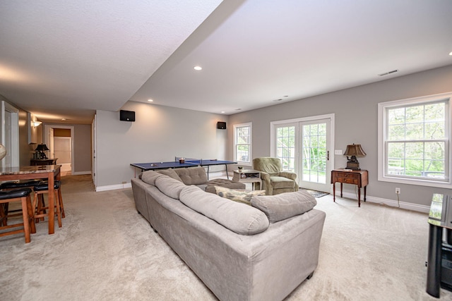 living room featuring visible vents, light colored carpet, and baseboards