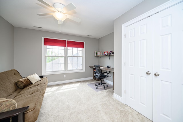 carpeted home office featuring a ceiling fan, visible vents, and baseboards