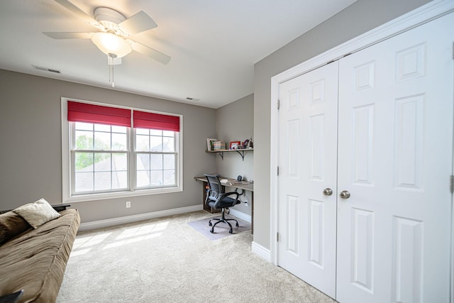 carpeted office space with baseboards, visible vents, and a ceiling fan