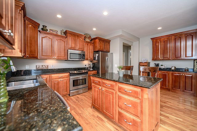 kitchen with light wood-style floors, stainless steel appliances, a kitchen island, and recessed lighting