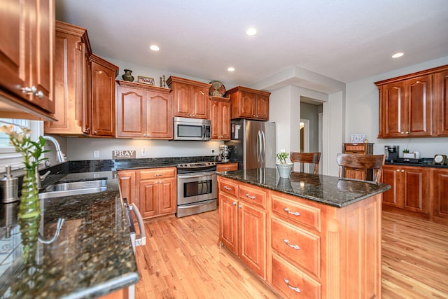 kitchen featuring a sink, appliances with stainless steel finishes, a center island, light wood-type flooring, and recessed lighting