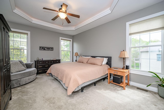 bedroom with a raised ceiling, visible vents, baseboards, carpet, and a ceiling fan