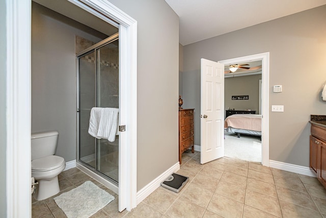 ensuite bathroom featuring toilet, vanity, a stall shower, and tile patterned flooring