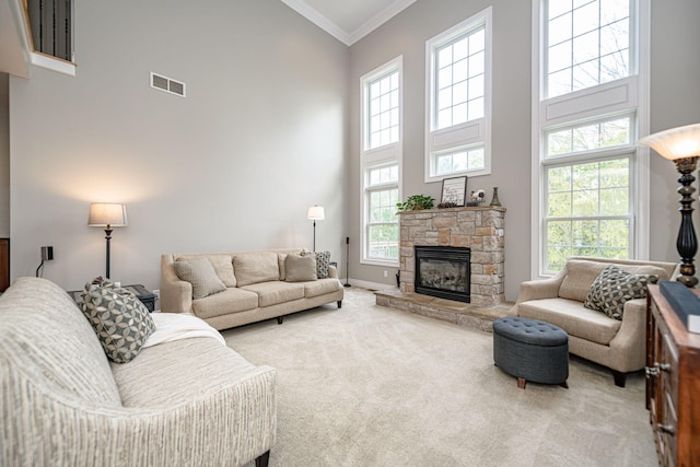 living room featuring a fireplace, visible vents, ornamental molding, a towering ceiling, and carpet floors