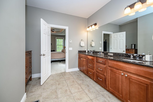 ensuite bathroom with tile patterned flooring, double vanity, a sink, and ensuite bath