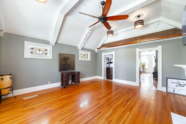unfurnished living room featuring ceiling fan, baseboards, vaulted ceiling with beams, and light wood-style flooring