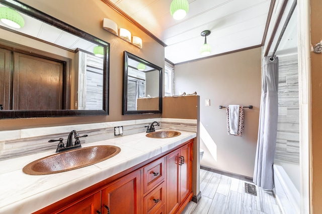 full bathroom featuring ornamental molding, a sink, visible vents, and double vanity