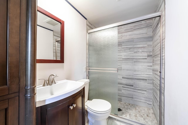 bathroom featuring a shower stall, toilet, vanity, and visible vents