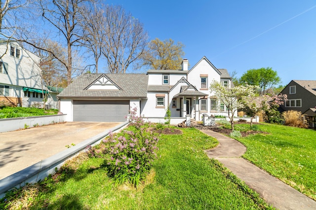 view of front of house featuring an attached garage, driveway, a front yard, and stucco siding