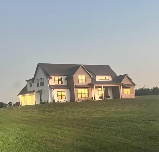 back of property with a lawn and an attached garage