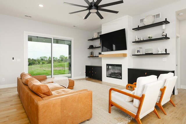 living area with ceiling fan, light wood-style flooring, and baseboards