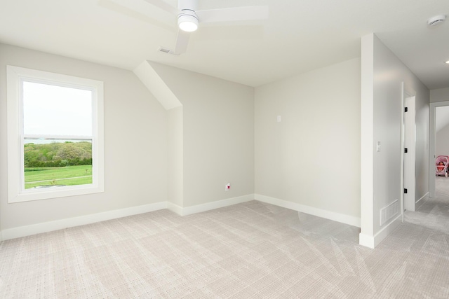 bonus room with a ceiling fan, visible vents, light colored carpet, and baseboards
