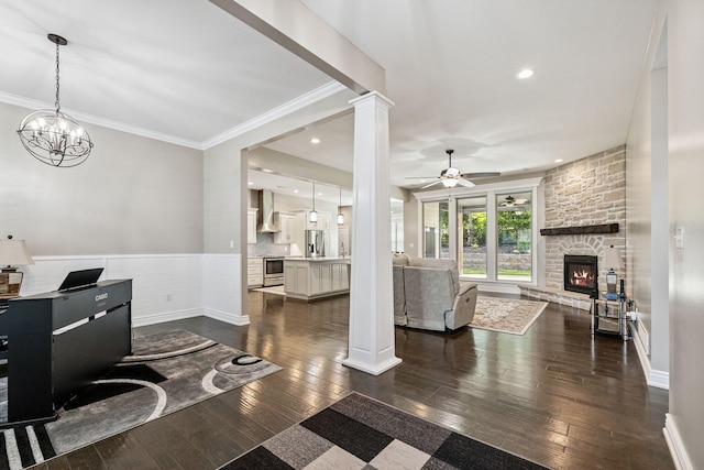 4210 Granite Springs Dr, Columbia, MO 65203 - living room featuring dark wood-style floors, a fireplace, ceiling fan, crown molding, and a wainscoted wall