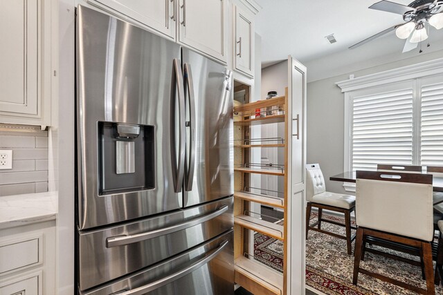 4210 Granite Springs Dr, Columbia, MO 65203 - kitchen featuring stainless steel refrigerator with ice dispenser, ceiling fan, tasteful backsplash, white cabinetry, and light stone countertops