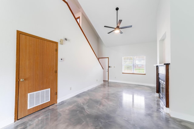 unfurnished living room with visible vents, concrete flooring, baseboards, a glass covered fireplace, and ceiling fan