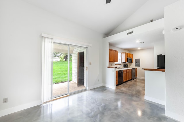 kitchen with electric panel, vaulted ceiling, concrete flooring, brown cabinetry, and black appliances
