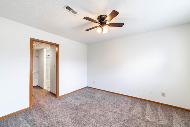 spare room with carpet floors, visible vents, baseboards, and ceiling fan