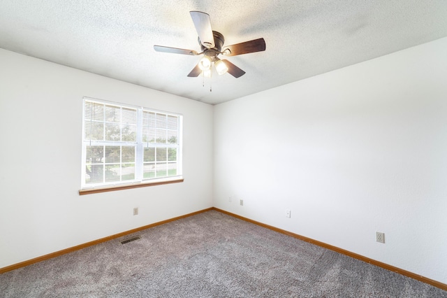 carpeted spare room featuring a textured ceiling, visible vents, baseboards, and ceiling fan