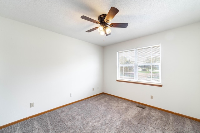 carpeted spare room with baseboards, visible vents, a textured ceiling, and ceiling fan