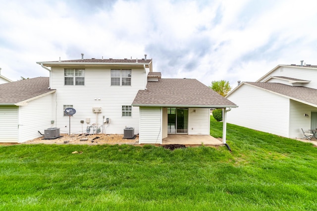 back of house with a lawn, a shingled roof, central air condition unit, and a patio