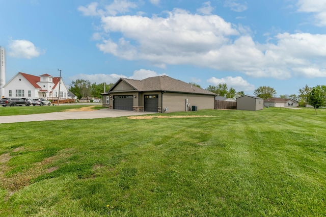 view of yard with an outdoor structure, concrete driveway, a storage unit, an attached garage, and fence