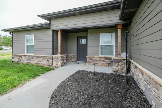property entrance with a porch and stone siding